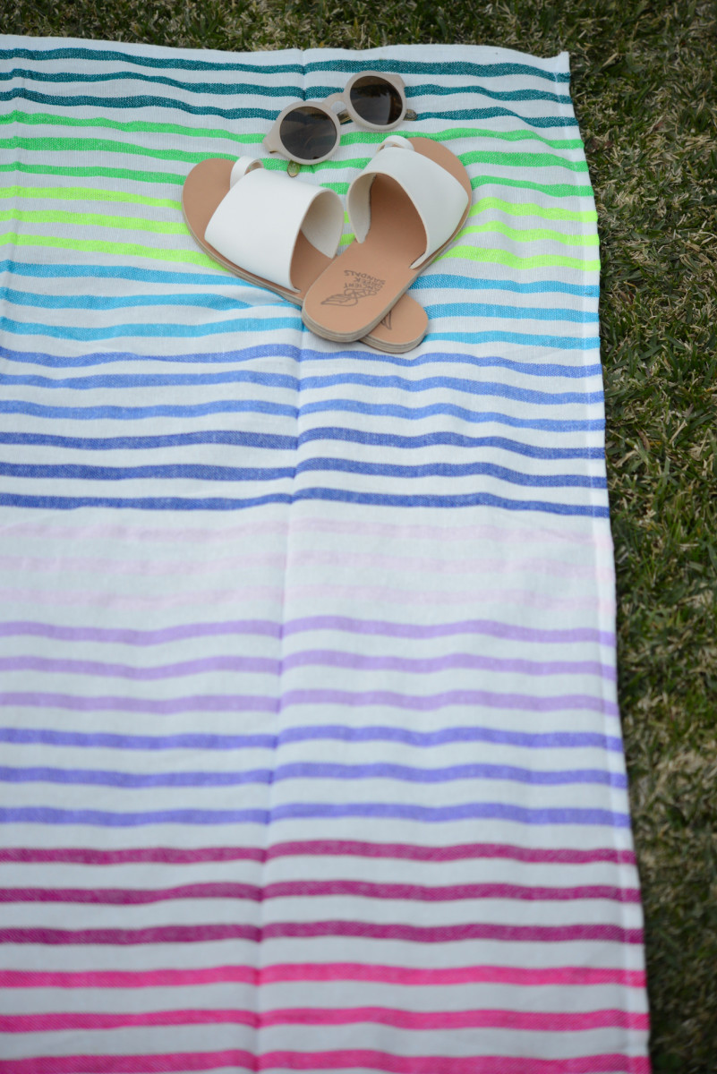 {A striped beach blanket we've been using on our lawn on warm afternoons}